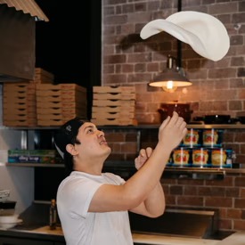 Pizza chef hand-tossing dough at The Grumpy Italian